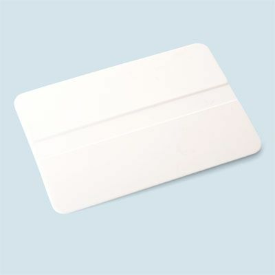 Ένα λευκό πλαστικό τετράγωνο που μπορεί να χρησιμοποιηθεί για να καθαρίσει τις φυσαλίδες αέρα όταν εφαρμόζετε ένα στένσιλ σε γυαλί για ένα έργο χάραξης γυαλιού DIY. 