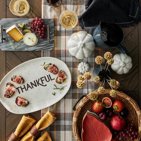 La cena del Ringraziamento è spalmata su un piatto con sopra la parola grato. 