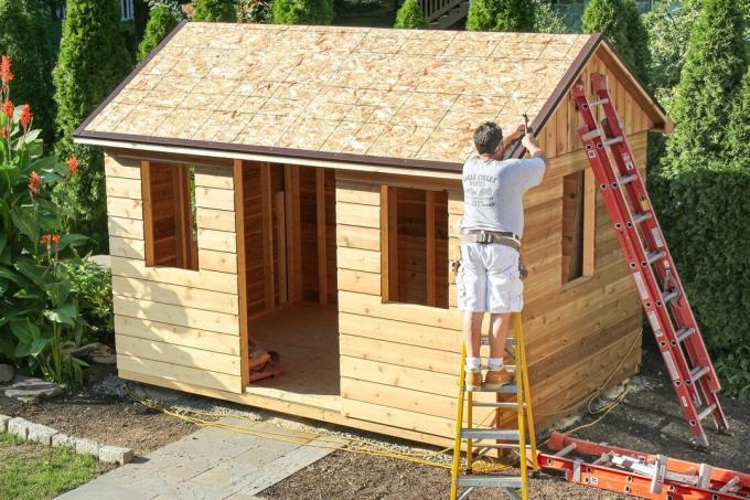 Mężczyzna buduje szopę ogrodową DIY od podstaw