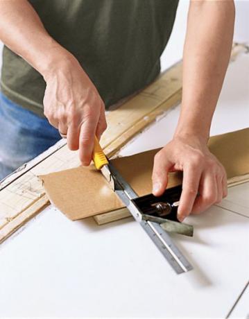 Človek naredi kartonsko predlogo pulta iz mesarskega bloka DIY