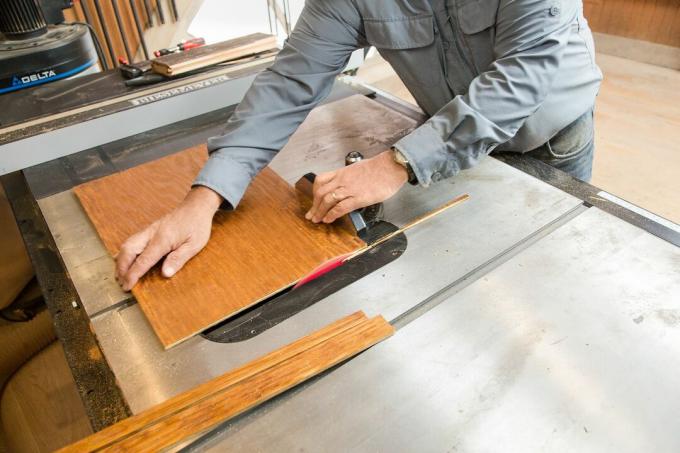  Persona cortando paneles de madera con una sierra de mesa.