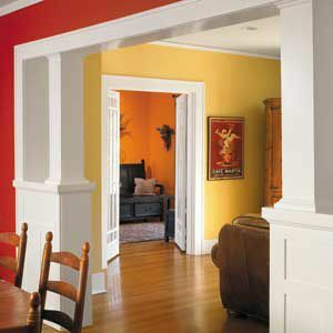 Dvojfarebné vnútorné steny s obývacou izbou natreté na žlto a kuchynské steny natreté červenou farbou.