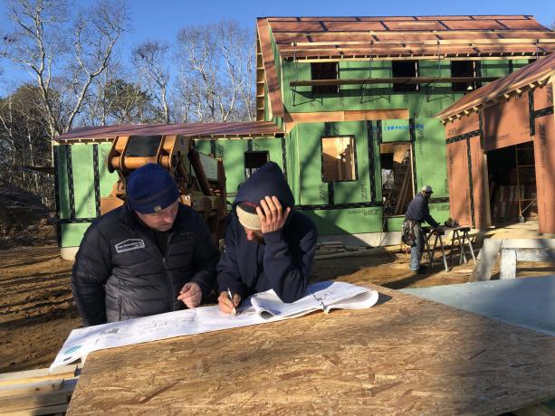 Besætningsmedlemmer studerer husplaner på TOH 2020 Idea House on the Cape.