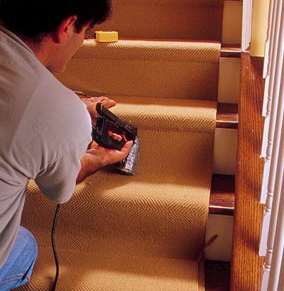 Az ember bemutatja, hogyan kell szőnyeget felszerelni a lépcsőn