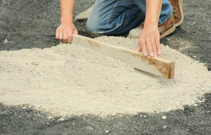 Oseba pripravi kamenčkov mozaik na kamnitem prahu