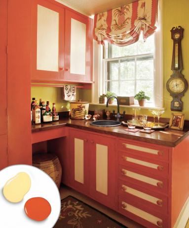 Двухцветный кухонный шкаф с красными шкафами и желтыми панелями.