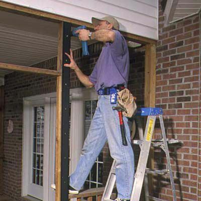 Man installerar vertikala basremsor för skärmad i veranda