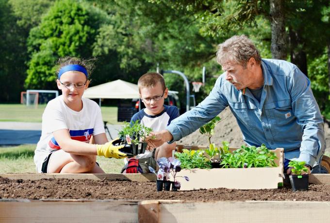 Roger Cook och upphöjd trädgårdssäng med barn