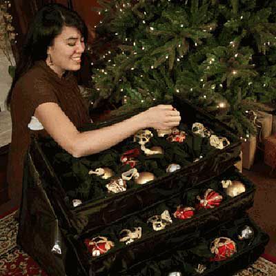 Osoba, která úhledně umístí vánoční ozdoby do ozdobné truhly.