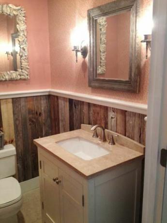 Painéis de madeira natural nas paredes de um pequeno banheiro. 