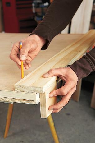 DIY बार के लिए लकड़ी के पैनल पर स्टाइल के अंदर के किनारे को चिह्नित करने वाला व्यक्ति
