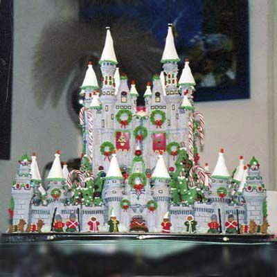 Detailliertes weißes Lebkuchenschloss verziert mit grünen Kränzen aus Zuckerguss. 
