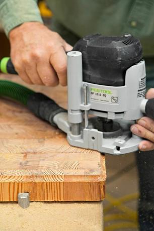 木のルーターを使ってエンドグレインまな板を仕上げる人。