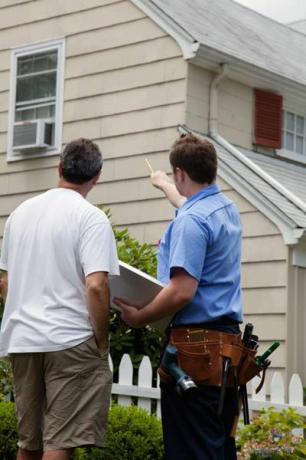 Auftragnehmer im Gespräch mit dem Hauseigentümer über Probleme mit undichten Dächern