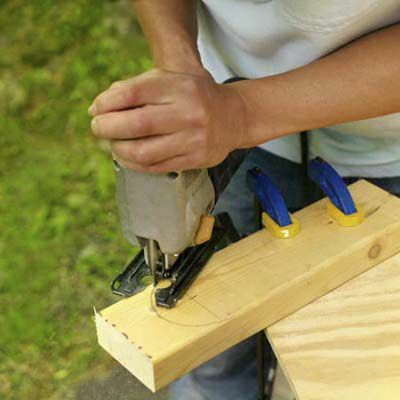 Uomo che taglia telai e gambe in legno 2x4 per tavole di cornhole