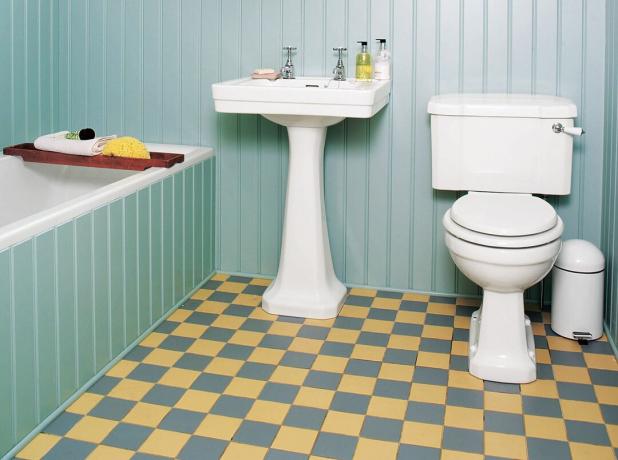 Pavimento del bagno a scacchiera gialla e grigia.