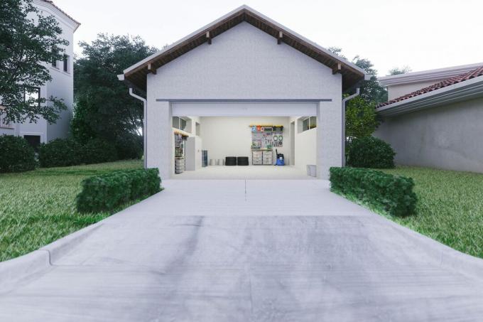 En betonguppfart som leder fram till ett fristående garage. 