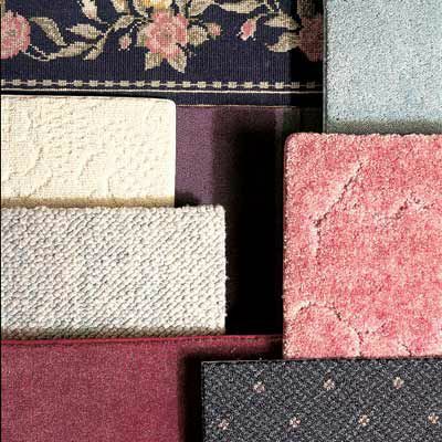 Daug skirtingų spalvotų kilimų pavyzdžių vienas šalia kito.