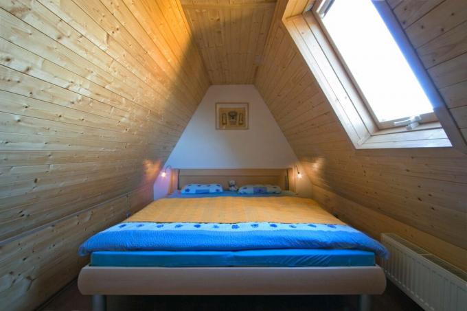 अटारी बेडरूम में लकड़ी की छत।