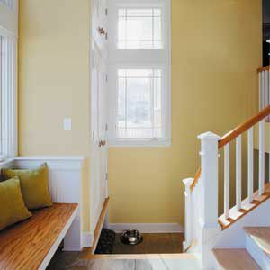Entrada de la casa con paredes interiores pintadas de amarillo.